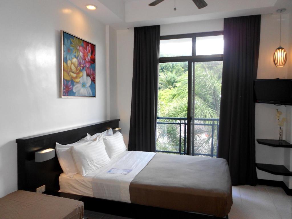 长滩岛新月广场酒店的酒店客房设有床和窗户。