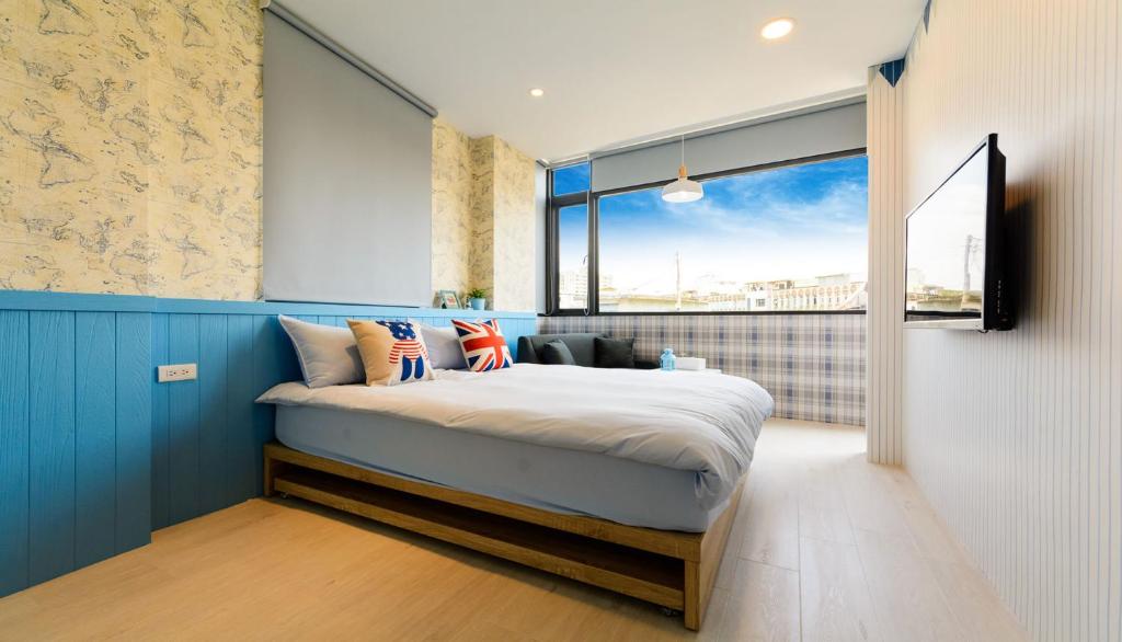 罗东镇宜蘭羅東迷彩民宿-大吉迷彩的一间卧室设有一张床和一个大窗户