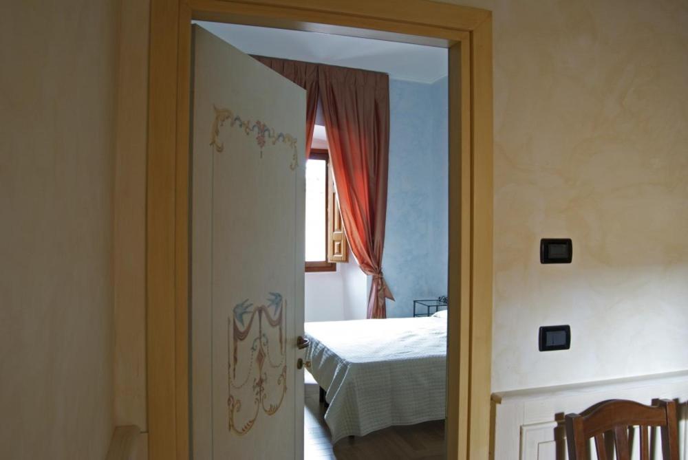 拉奎拉B&B Palazzo Cappa的通往卧室的开放式门,卧室配有床