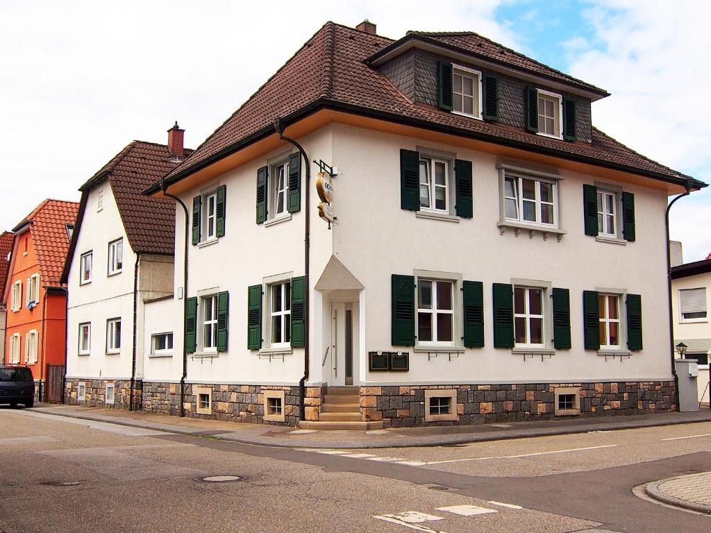 洛尔施Gasthof Schillereck的街上的白色房子,有绿色百叶窗