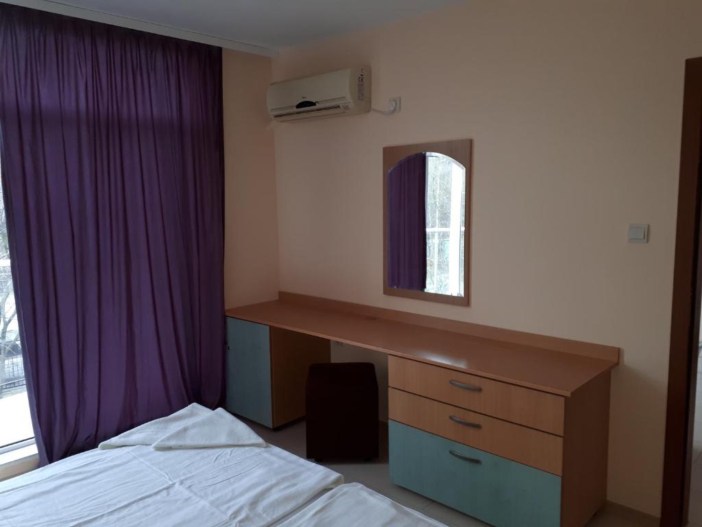 拉夫达Apart Hotel Ravda的一间卧室配有一张床、一张书桌和一个窗户。