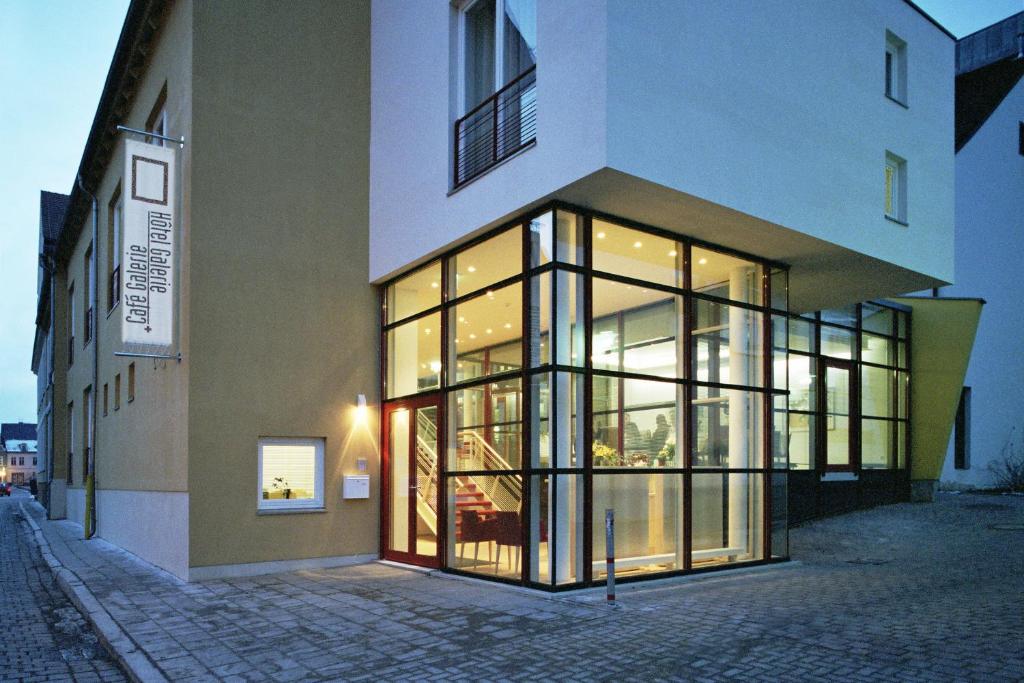 格赖夫斯瓦尔德Hôtel Galerie的街道上设有大型玻璃窗的建筑