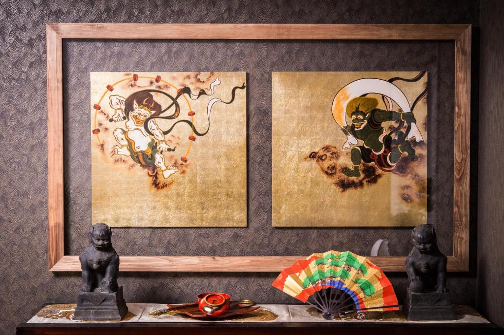 京都布达度假屋的架子上摆放着两幅画,两幅雕像和一把伞