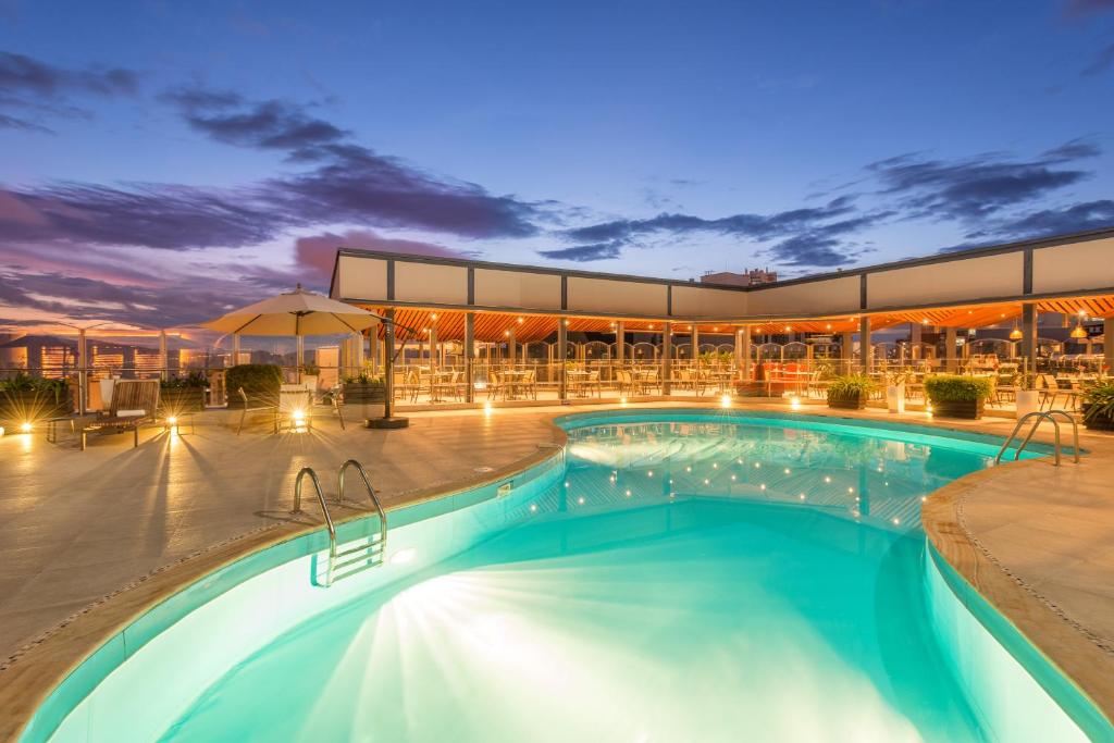 布卡拉曼加布卡拉曼加丹恩卡尔顿酒店的一座游泳池,在晚上在建筑物前