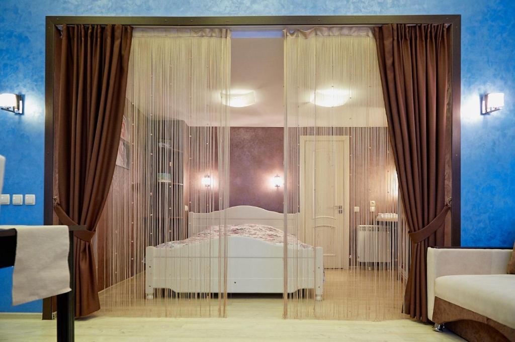 大卢基Idillia Mini Hotel的一间卧室设有一张床和玻璃墙
