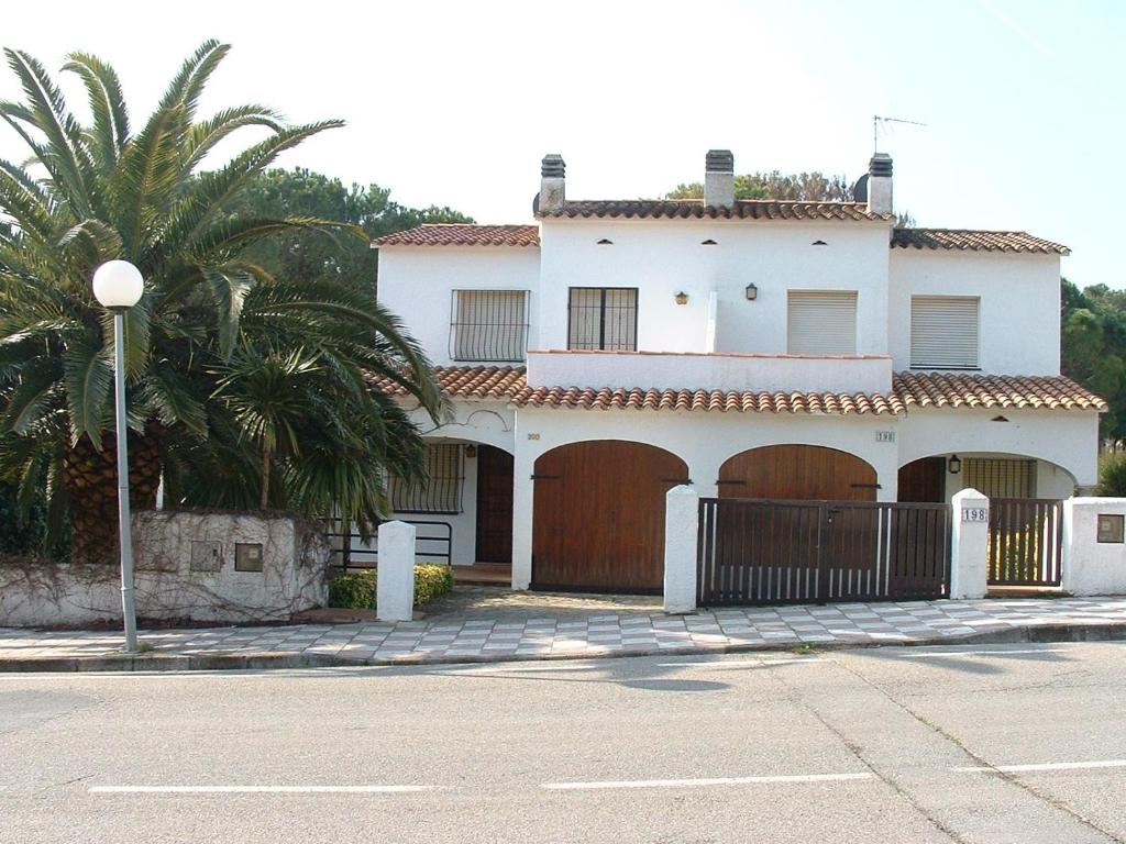 莱斯卡拉Casas Montgo Park的两扇车库门和棕榈树的白色房子