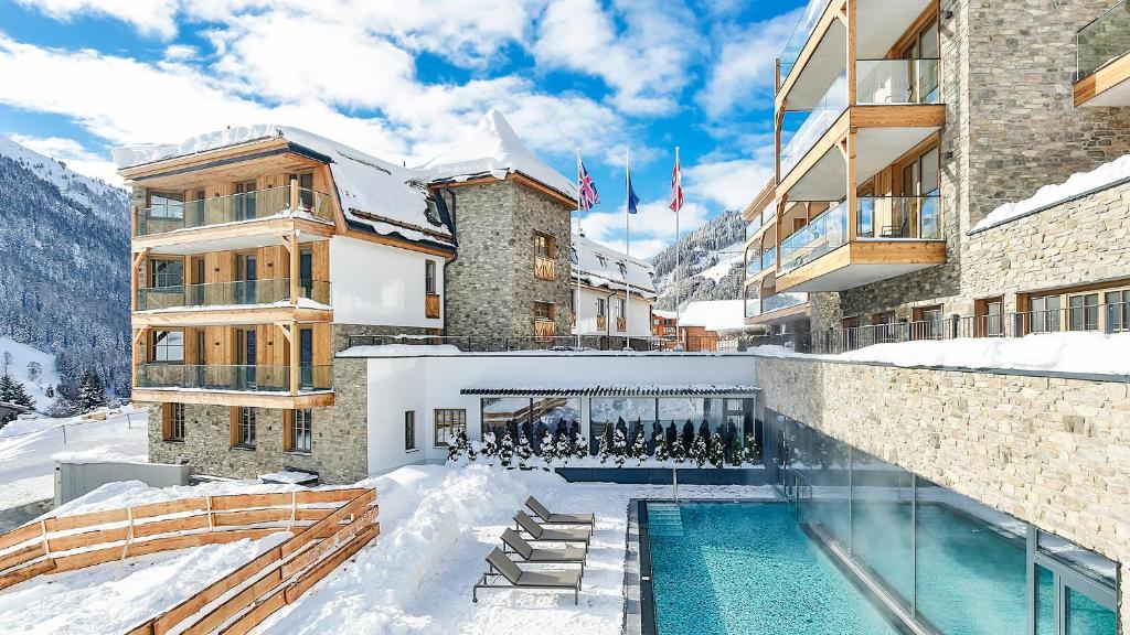 圣安东阿尔贝格Mountain Spa Residences的一座在雪中设有游泳池的建筑
