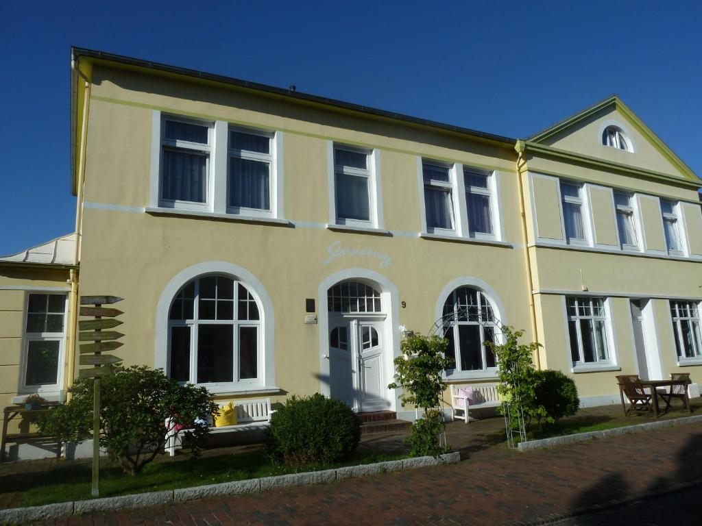 万根沃格Haus Strandburg的黄色的房子,有白色的门和窗户