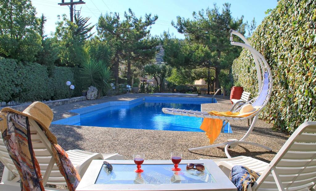 阿卡尼斯Villa Kazantzakis的一个带桌子和两把椅子的游泳池以及一张桌子