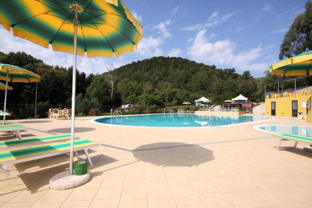 里奥马里纳坎纳俳野营村酒店的一个带两把椅子和遮阳伞的游泳池
