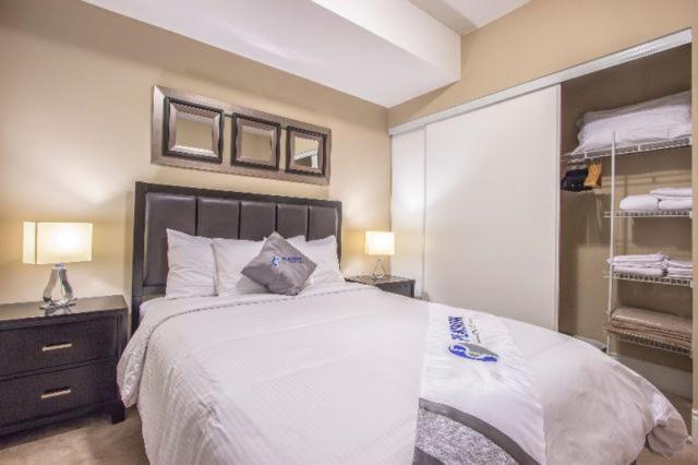 米西索加Platinum Suites Furnished Executive Suites的卧室配有一张白色大床和一个衣柜