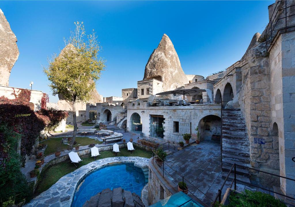 格雷梅Anatolian Houses Cave Hotel & SPA的享有带游泳池的建筑的空中景致