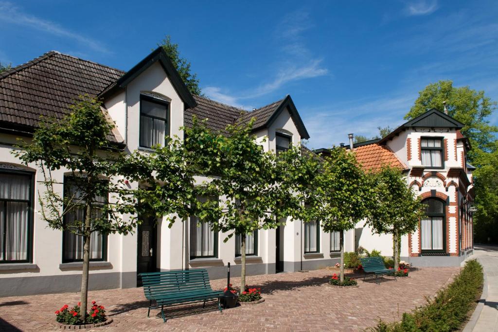 温特斯韦克Hotel Restaurant Mondriaan的前面有绿色长椅的房子