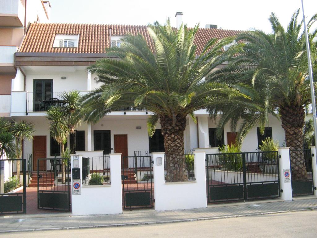 圣贝内代托-德尔特龙托Residence Dolcemare的前面有棕榈树的房子