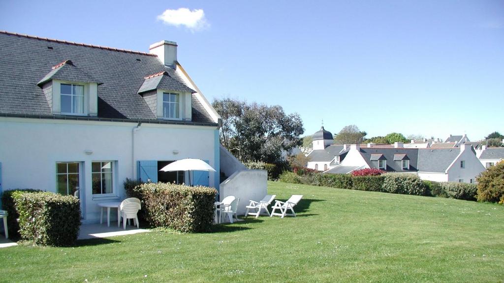 洛克马里亚Maison avec vue sur mer dans Résidence Marie Galante的草坪上带椅子和遮阳伞的房子
