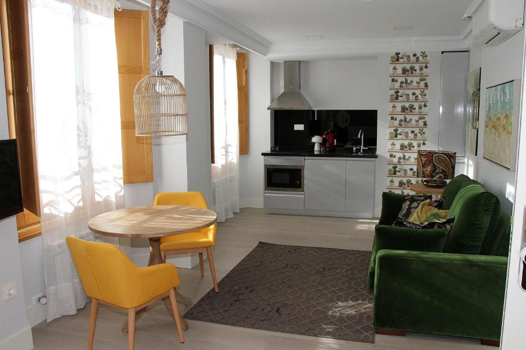 莱昂Principia Suites的客厅配有桌子和绿色沙发