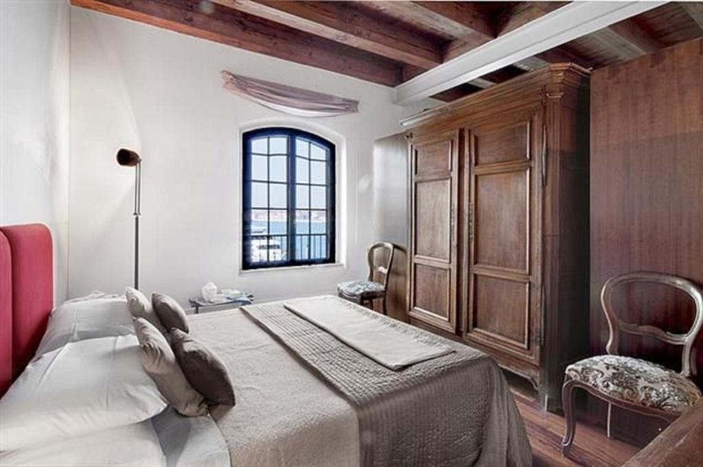 威尼斯伊尔茉莉诺公寓的一间卧室设有一张大床和一个窗户。
