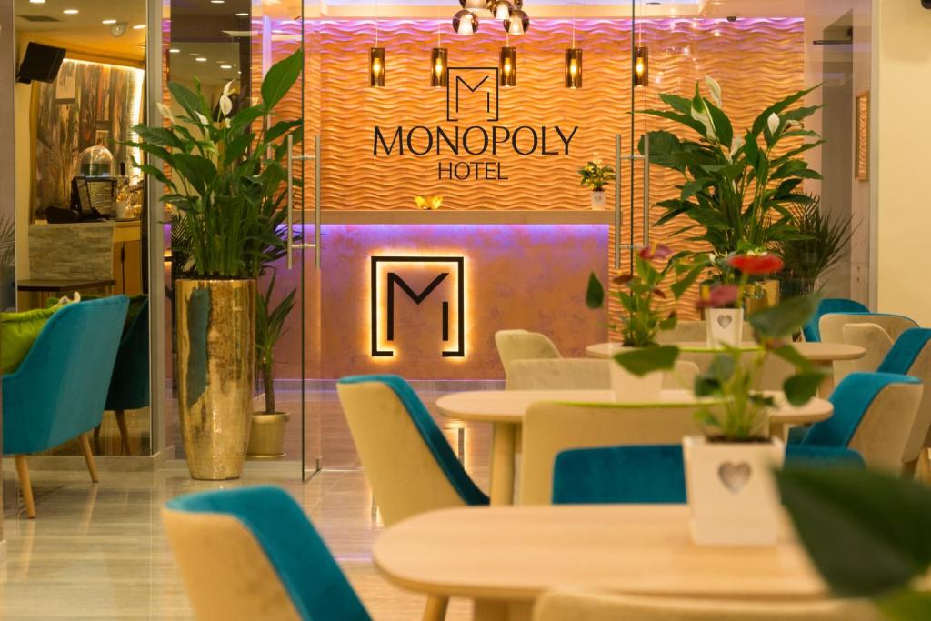 奥托佩尼Monopoly Hotel的一家餐厅,配有桌椅和阅读垄断酒店的标志