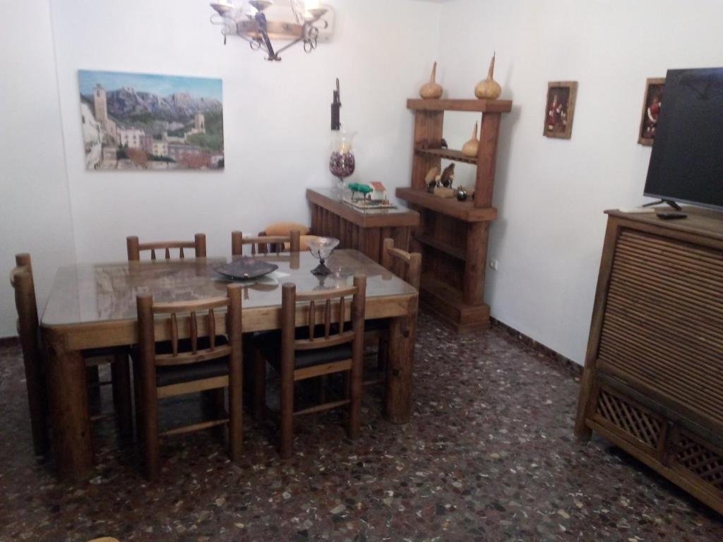 卡索拉Casa La Antigua Almazara的一间带桌椅和电视的用餐室