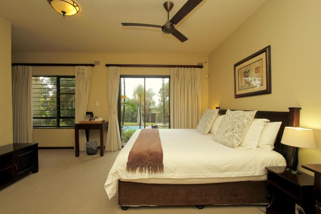 德班特索日诺住宿加早餐酒店的一间卧室配有一张大床和吊扇