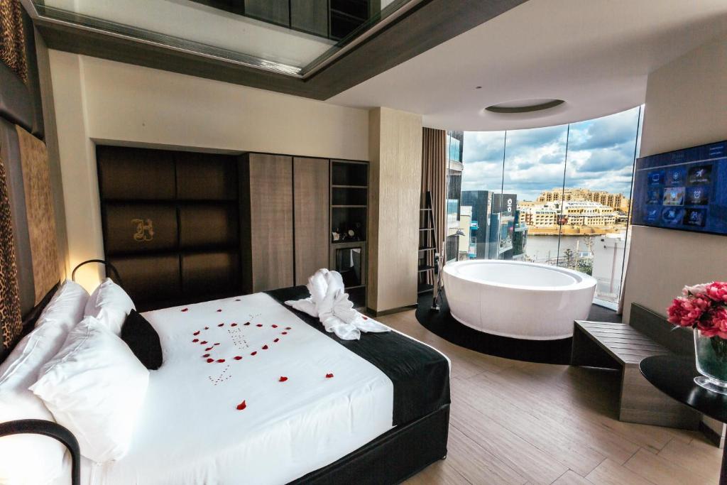 圣朱利安斯雨果精品酒店 - 仅限成人的一间卧室设有一张大床和一个浴缸