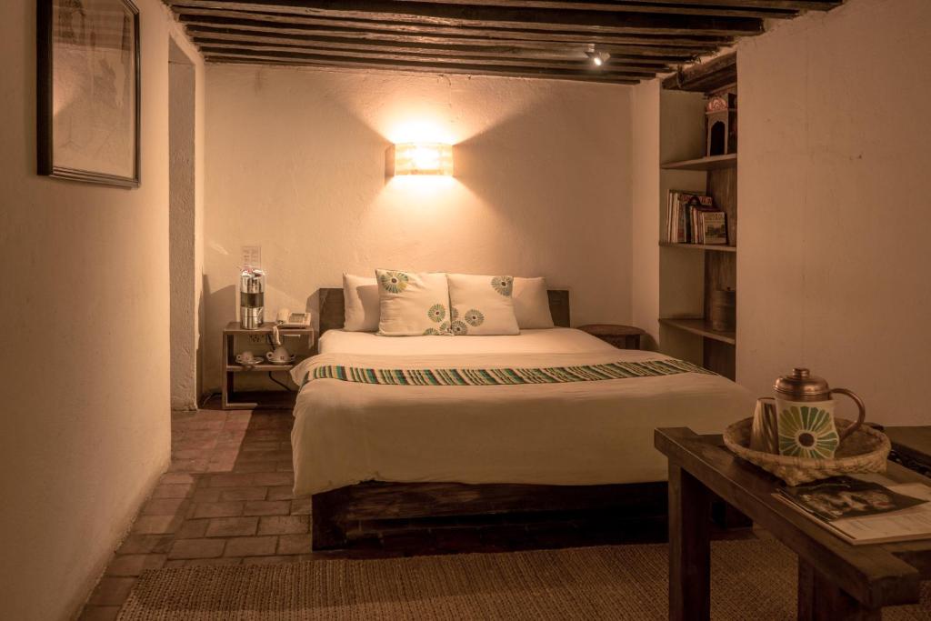 巴克塔普尔皮亚科克宾馆的一间卧室配有一张床和一张带台灯的桌子
