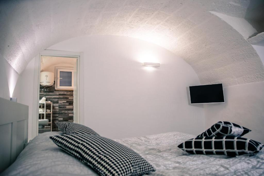 莫诺波利Casa Vacanze Antiche Mura E Poi的卧室配有一张床,墙上配有电视。