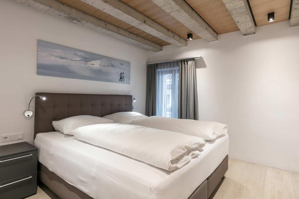 基茨比厄尔Doris' Nest的一间卧室配有一张带白色床单的床和一扇窗户。