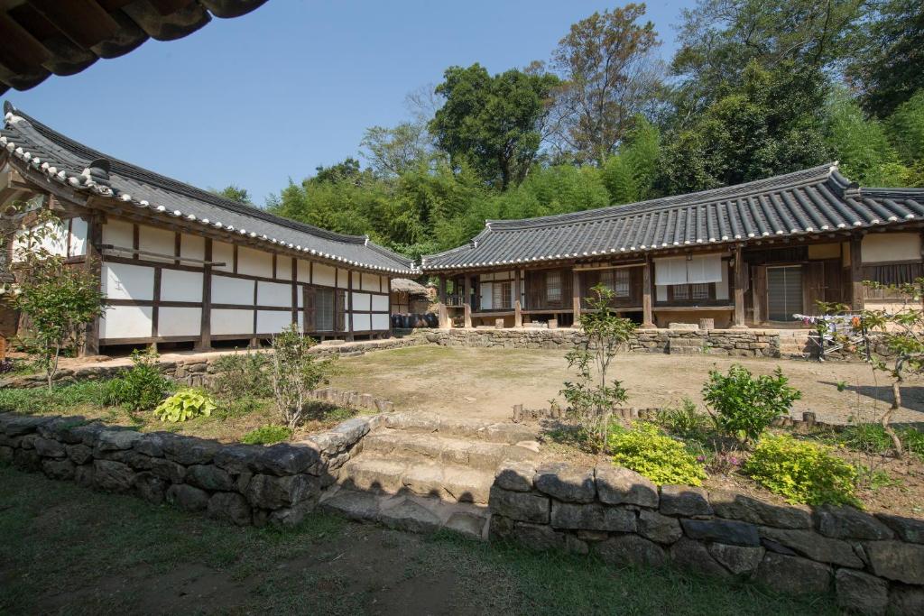 宝城郡Jinrae Lee's Traditional House的前面有花园的建筑