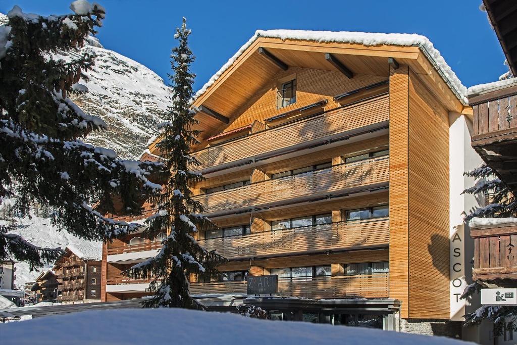 采尔马特Ascot-Zermatt的一座大建筑,有雪覆盖的山