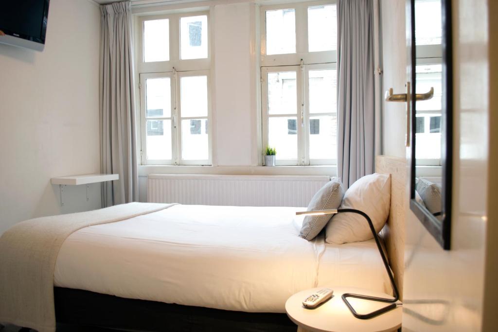 马斯特里赫特比兹酒店的一间卧室配有一张带桌子和窗户的床。