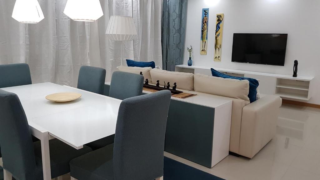 普拉亚Elegant Modern Blue Apartment的客厅配有桌子和沙发,沙发上配有棋盘