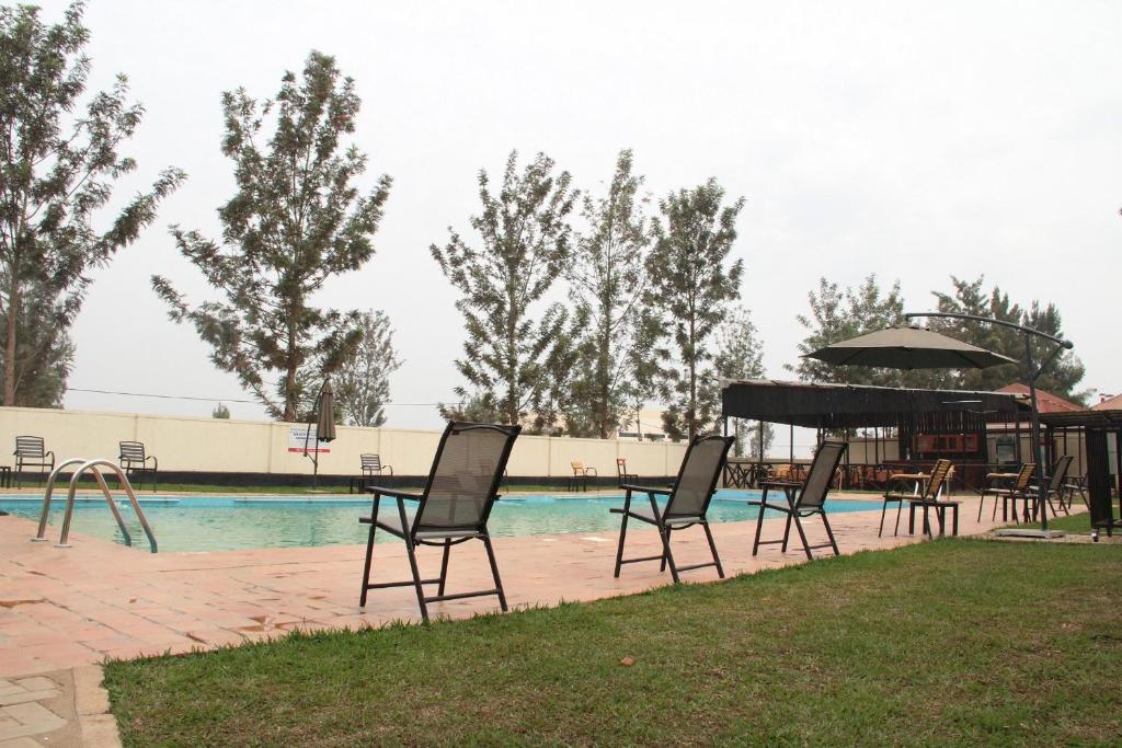 NyagatareNyagatare Diplomat Hotel的游泳池旁设有椅子和钢琴的游泳池
