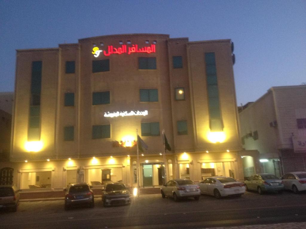 利雅德Al Makan Al Mosafer 116 Hotel by Al Azmy的酒店大楼前面设有停车场