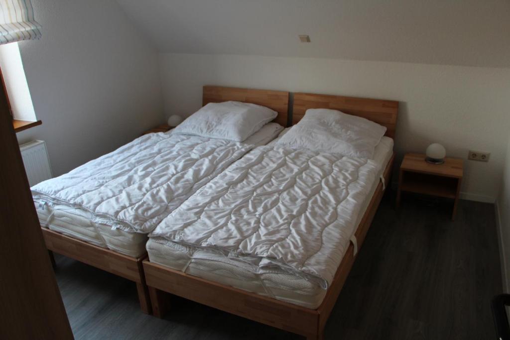 MinsenFerienwohnungen Hensel的卧室配有一张带白色床单和枕头的大床。