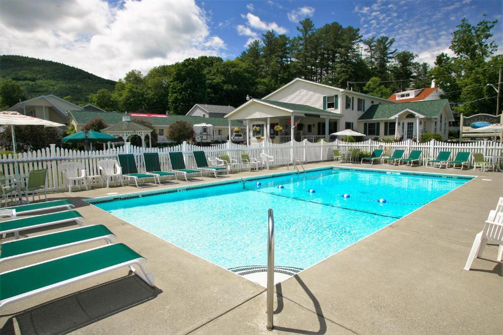 乔治湖乔治湖传统汽车旅馆的一个带椅子的游泳池以及一座房子