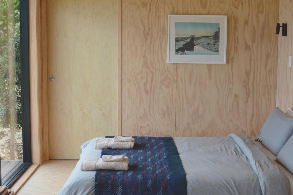 阿希帕拉The Huts的一间卧室配有带毛巾的床