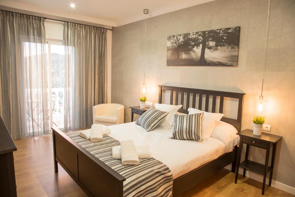 卡尼利亚斯-德阿尔拜达赫尔米拉多公寓的一间卧室设有一张大床和一个大窗户