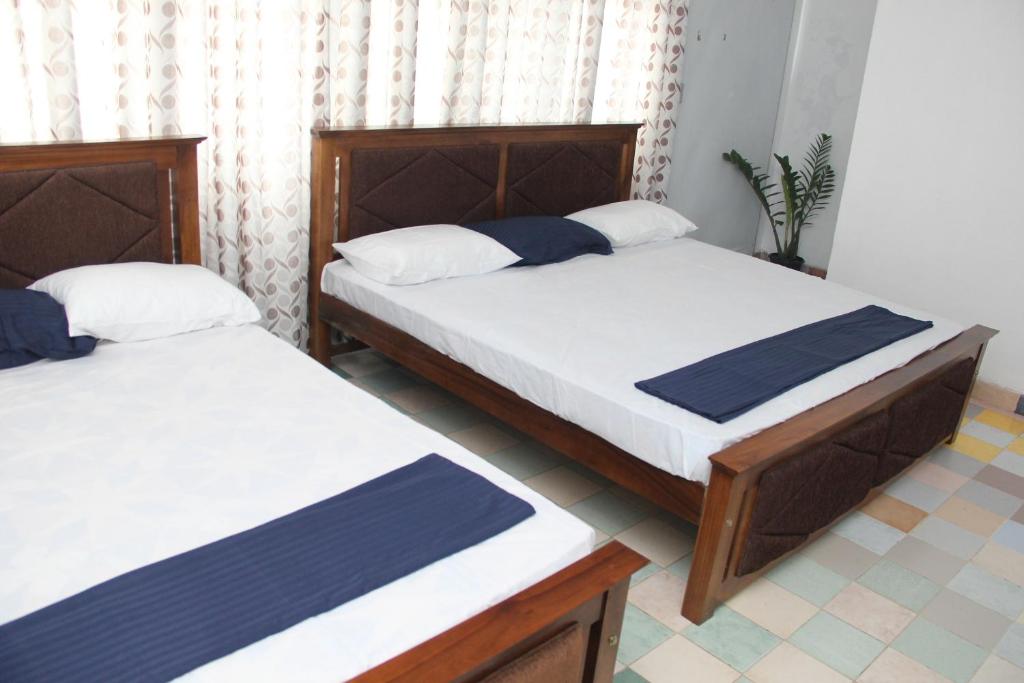 阿努拉德普勒Kingfisher Hostel的两张位于小房间的床,有背风
