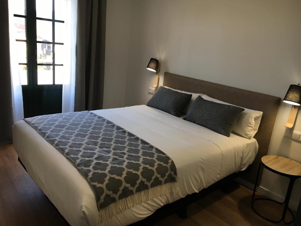 圣地亚哥－德孔波斯特拉Lux Apartamentos Rosalia的一间卧室配有一张带蓝色枕头的大床