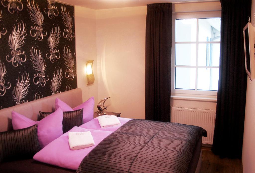 巴贝Sun Island的一间卧室配有带粉红色枕头的床和窗户。