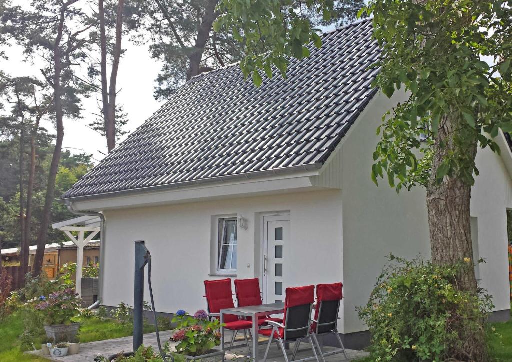 科尔平塞Ferienhaus Koelpinsee USE 2871的白色房子前面的一张桌子和椅子