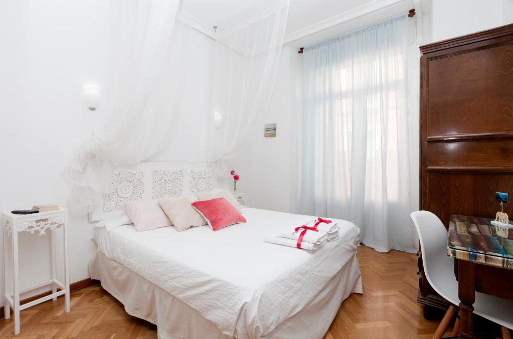 马德里西班牙大街公寓的白色卧室配有白色床和粉红色枕头