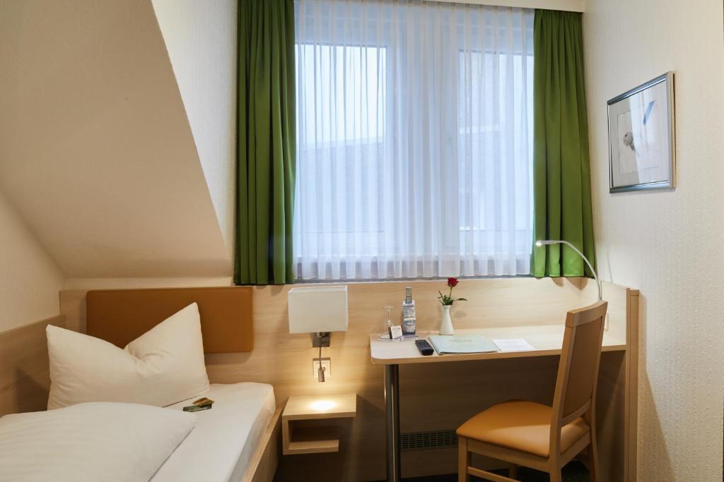 费尔贝特祖尔特劳博酒店的配有一张床、一张书桌和一扇窗户的酒店客房