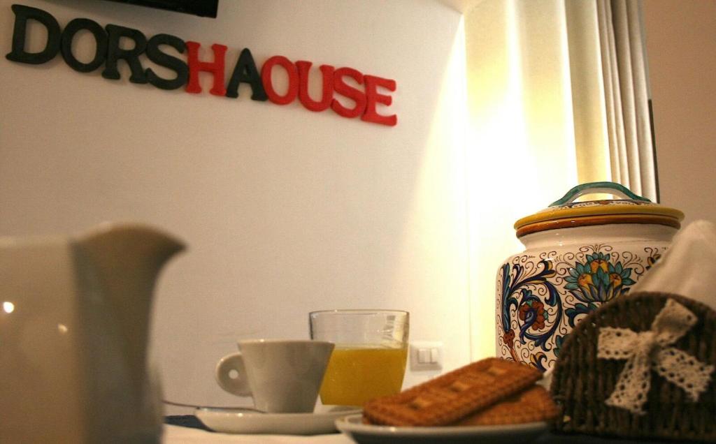 奇维塔韦基亚dorshaouse的一张桌子,上面有花瓶和一盘饼干和橙汁