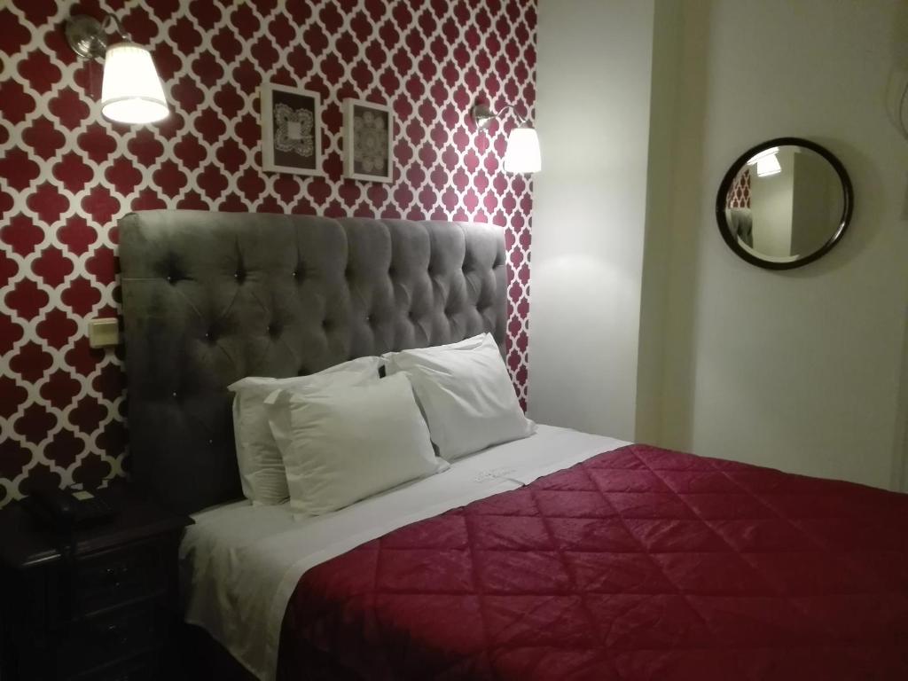 托马尔卡曼加酒店的一间卧室配有一张红色棉被的床