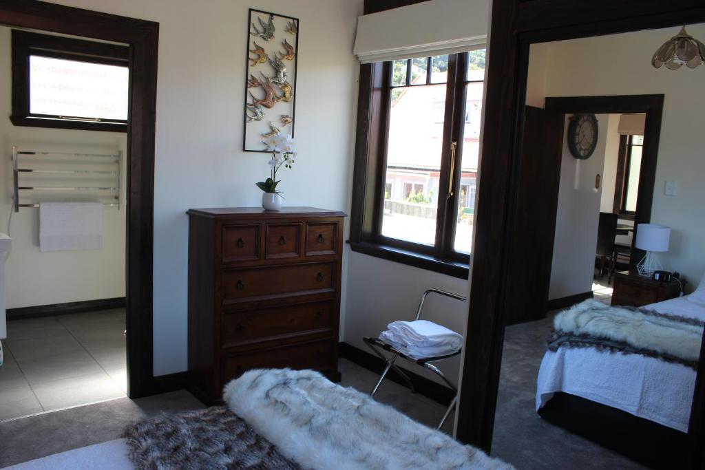 惠灵顿Casa Felina Apartment的一间带镜子、梳妆台和床的卧室