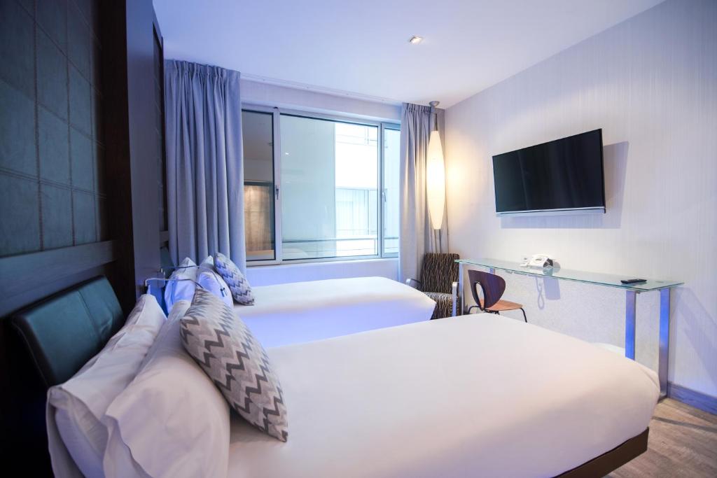 马德里卡斯特拉纳珀蒂宫总统酒店的一间酒店客房,设有两张床和电视