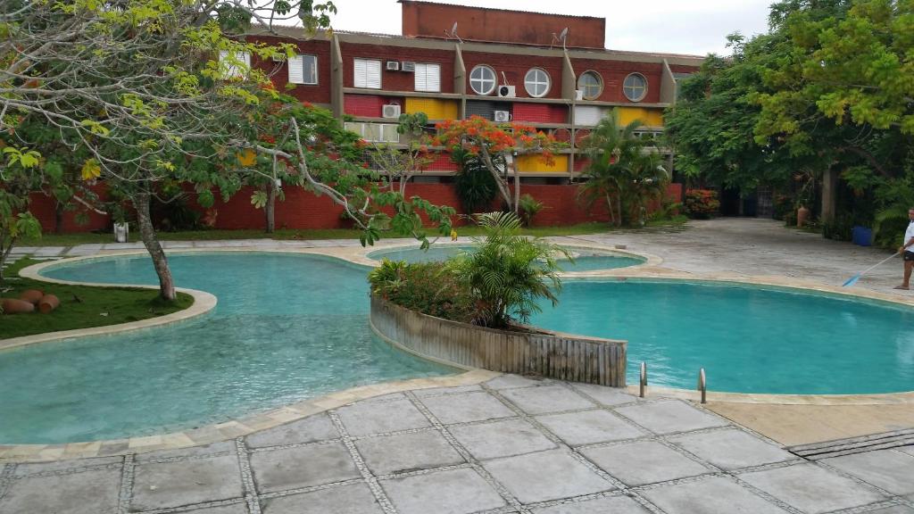 阿尔科巴萨Flat Condominio Gaivotas Alcobaça BA a 100 metros do mar的一座大楼前空的游泳池