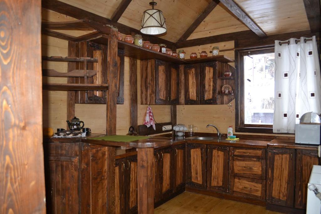 布克维Шале "Конопка"的厨房配有木制橱柜、水槽和窗户。
